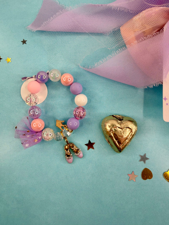 Colorful beaded bracelet with charms on a light blue background