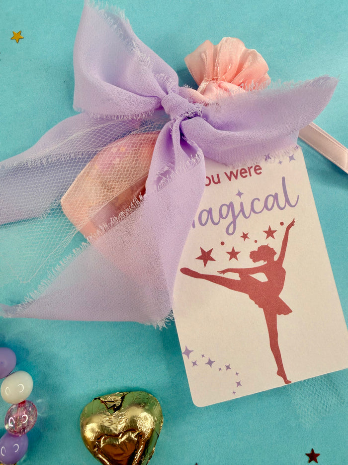 Ballet-themed gift bag with a tag and decorative elements on a blue background