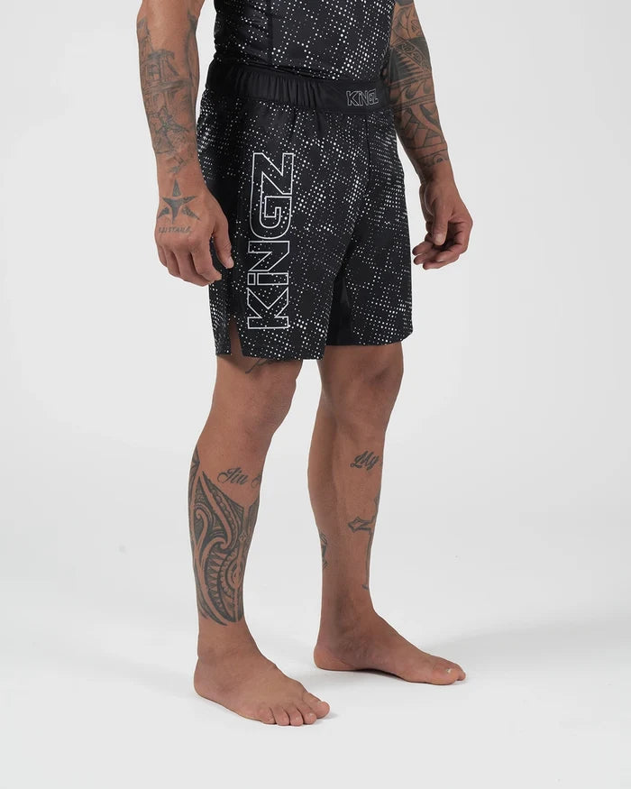 Kingz Acid Wash Shorts Black - Full Body 3/4 Front Right Angled View Tattooed Male Athlete KINGZ Large Outline White Text Left Leg Black White Dot Acid Wash Pattern Sublimated Men's Grappling Shorts No-Gi BJJ [color:Black/Patterned]