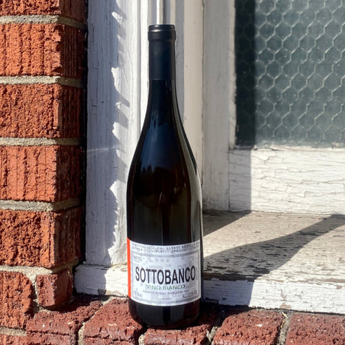 Andrea Occhipinti Sottobanco white wine bottle, 2023, front label visible on dark glass