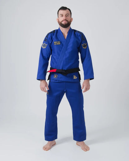 Kingz Comp 450 V6 Jiu Jitsu Gi Blue - Full Body Front View Male Athlete Blue Gi Black Kingz Shoulder Text Gold Crown Shoulder Patches Black Belt Heavy Lies The Crown Patch BJJ Gi Training [color:Blue]