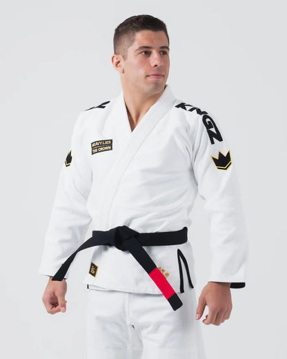 Kingz Comp 450 V6 Jiu Jitsu Gi - White - Three Quarter Front View Male Athlete Black Belt Shoulder Logos Crown Badge Chest Patch Heavy Lies The Crown Text BJJ Gi Training [color:White]