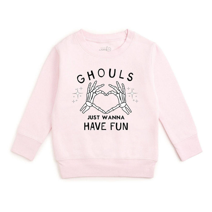 A light pink long-sleeve crewneck sweatshirt featuring a black graphic print of skeleton hands forming a heart shape with the text 'GHOULS JUST WANNA HAVE FUN' on a plain white background.