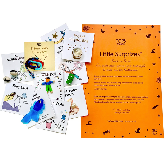 Assorted small surprise toys and cards designed for Halloween, including a crystal ball, dreamcatcher, and other small items packaged in a colorful box with 'Little Surprises' text.