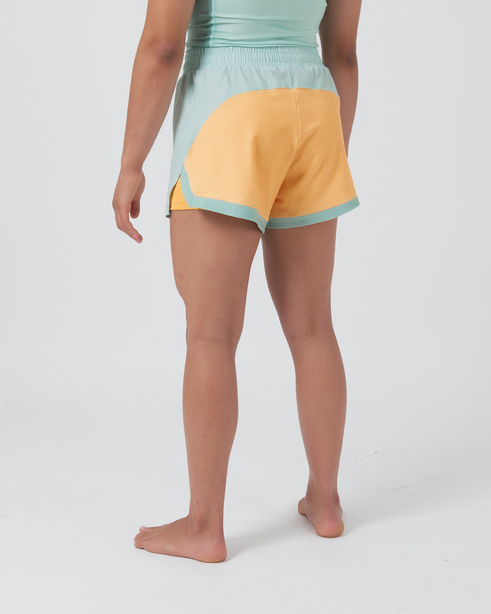 Kingz Hybrid Women's Shorts Terra Green - Full Body Left-Back Side Profile Female Athlete Two-Tone Design Mint Green Front Panel Golden Yellow Back Panel Mint Green Waistband Color Block Women's Grappling Shorts No-Gi BJJ [color:Light Green]