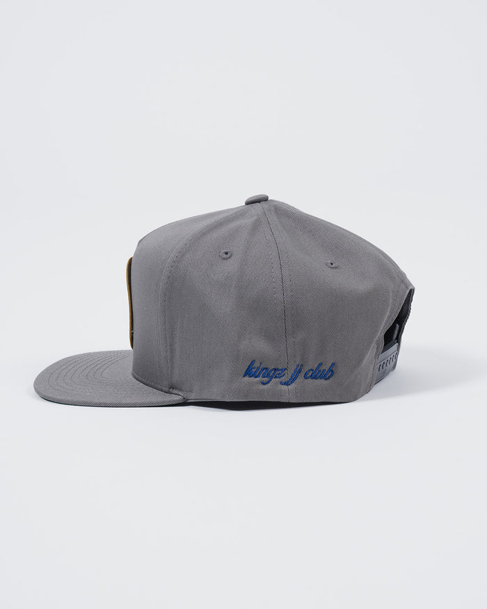 Kingz Jiu Jitsu Club Snapback Grey - Side View Embroidered Blue "kingz j club" Text Adjustable Snap Closure Flat Brim Classic Style BJJ Hat [color:Grey]