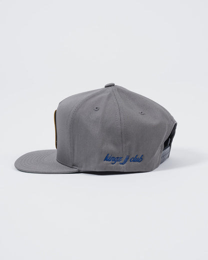 Kingz Jiu Jitsu Club Snapback Grey - Side View Embroidered Blue "kingz j club" Text Adjustable Snap Closure Flat Brim Classic Style BJJ Hat [color:Grey]