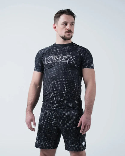 Kingz Acid Wash Rashguard Black - Full Body Front View Male Athlete Short Sleeve Large KINGZ Bold Text White Outline Black Dot Acid Wash Sublimated Pattern Matching Shorts [color:Black/Acid]