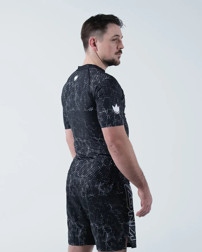 Kingz Acid Wash Rashguard Black - Full Body 3/4 Back View Left Side Male Athlete Short Sleeve Crown Logo Acid Wash Dot Pattern KINGZ Text Shorts Modern Training Gear [color:Black/Acid]