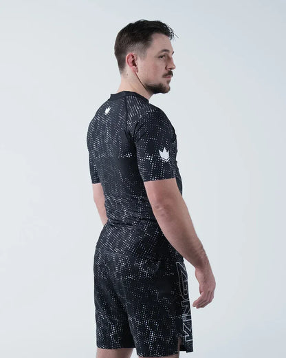 Kingz Acid Wash Rashguard Black - Full Body 3/4 Back View Left Side Male Athlete Short Sleeve Crown Logo Acid Wash Dot Pattern KINGZ Text Shorts Modern Training Gear [color:Black/Acid]