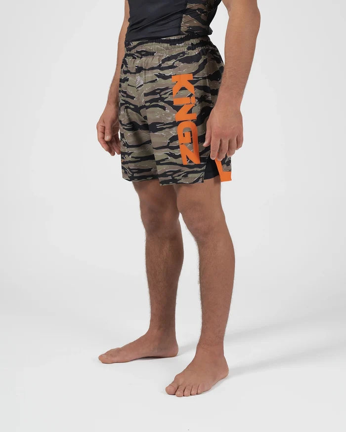 Kingz Always Hunting Shorts Green Camo - Full Body Right Side Profile Male Athlete Tiger Camo Pattern KINGZ Bold Orange Text Left Leg Orange Side Panel Lower Competition Cut Men's Grappling Shorts No-Gi BJJ [color:Green Camo]