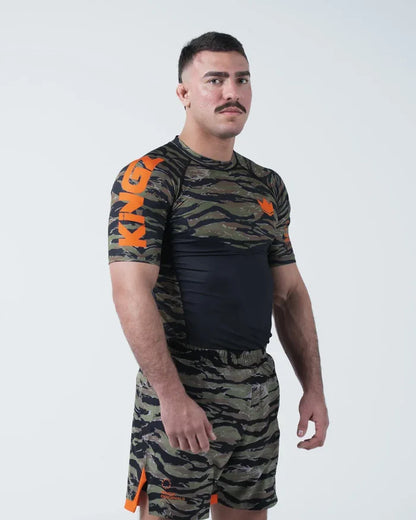 Kingz Always Hunting Rashguard Green Camo - Full Body 3/4 Angled View Left Side Male Athlete Short Sleeve Tiger Camo Orange Crown Logo Large KINGZ Text Sleeve Camo Shorts [color:Green Camo]