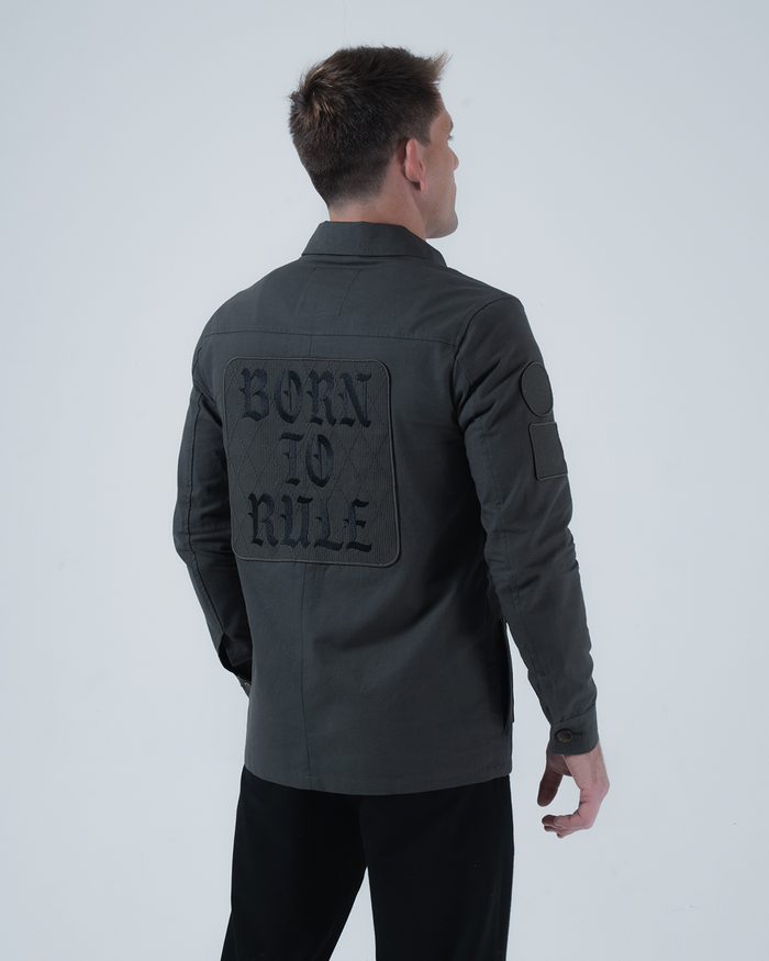 Kingz Born To Rule Canvas Jacket Military Green - Back View Male Model Large "BORN TO RULE" Text Back Patch Button Cuffs Quilted Texture Arm Patch Tailored Fit Outerwear BJJ Training [color:Military Green]