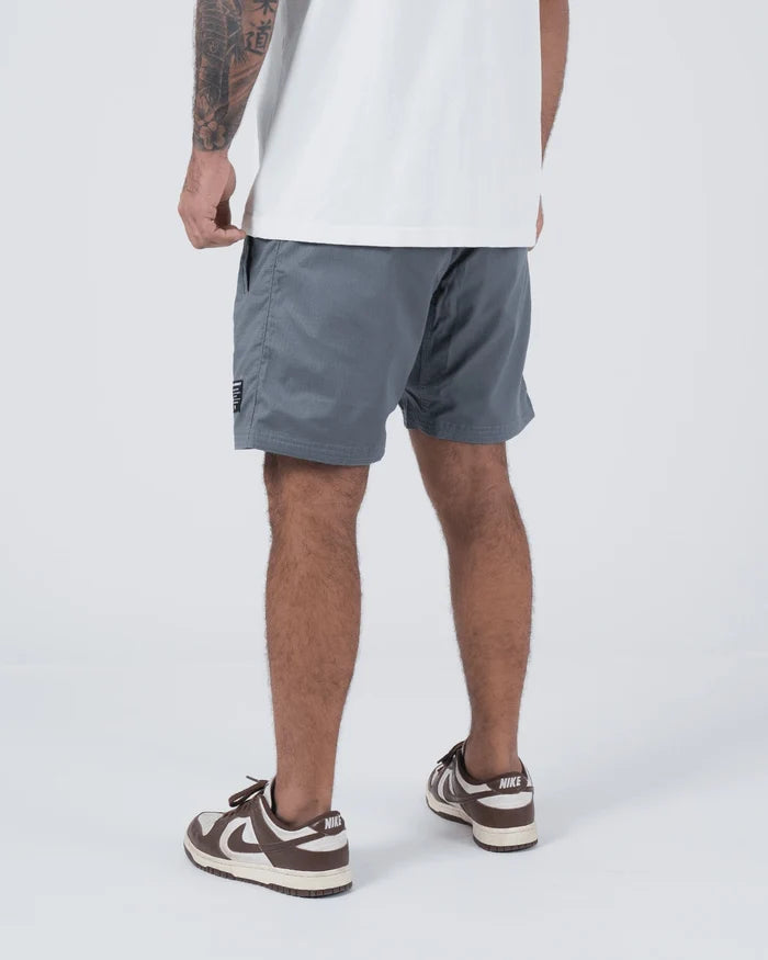 Kingz Casual Gi Shorts Grey Steel Blue-Grey - Full Body Left Side Profile Male Athlete Grey Ripstop Casual Shorts Relaxed Fit Black Woven Kingz Label Right Thigh White T-Shirt Brown Nike Dunk Sneakers Men's BJJ Lifestyle [color:Grey]