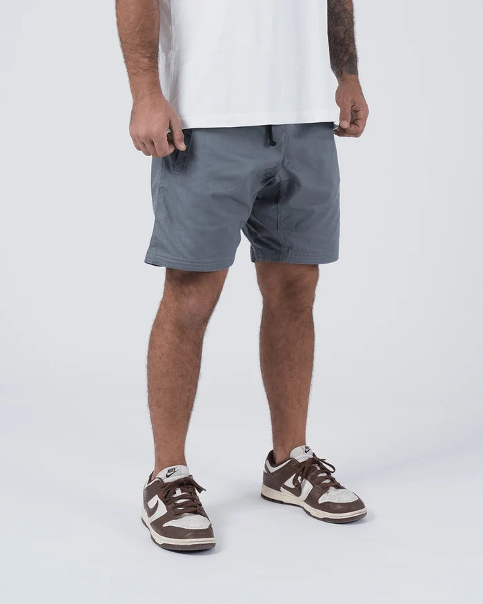 Kingz Casual Gi Shorts Grey Steel Blue-Grey - 3/4 Angled Front View Male Athlete Grey Ripstop Casual Shorts Hand on Drawstring Waistband Relaxed Fit Above-Knee White T-Shirt Brown Nike Dunk Sneakers Men's BJJ Lifestyle [color:Grey]