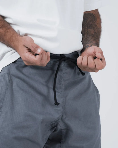 Kingz Casual Gi Shorts Grey Steel Blue-Grey - Close Up Waistband Detail Black Drawstring Hanging Front Grey Ripstop Fabric Texture Hands on Waistband Close Up Men's BJJ Lifestyle Casual Shorts [color:Grey]