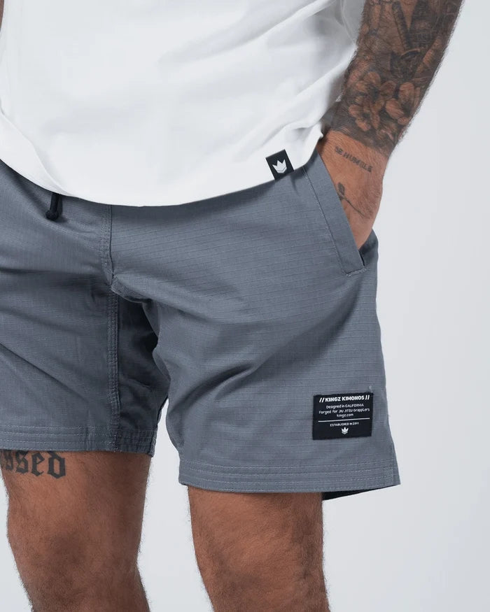 Kingz Casual Gi Shorts Grey Steel Blue-Grey - Close Up Label and Pocket Detail KINGZ KIMONOS Woven Label Right Thigh Crown Logo Front Waistband Grey Ripstop Fabric Side Pocket Above-Knee Relaxed Fit Men's BJJ Lifestyle [color:Grey]