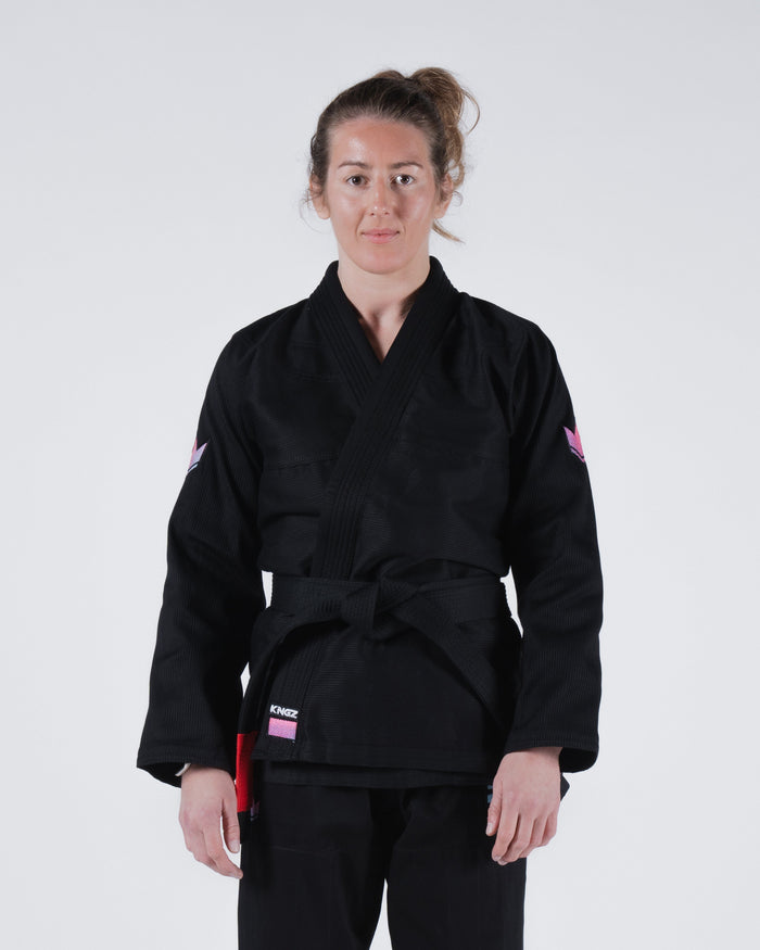 Kingz Empowered Women's Jiu Jitsu Gi - Black - Front View Female Athlete Black Gi Pink Accents Kingz Logo Left Waist Pink Crown Badge Sleeves Durable Weave Women's BJJ Gi Training [color:Black]