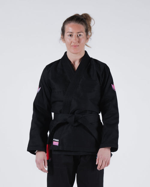 Kingz Empowered Women's Jiu Jitsu Gi - Black - Front View Female Athlete Black Gi Pink Accents Kingz Logo Left Waist Pink Crown Badge Sleeves Durable Weave Women's BJJ Gi Training [color:Black]