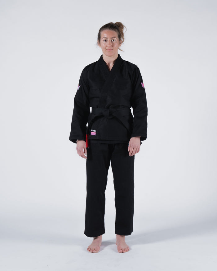Kingz Empowered Women's Jiu Jitsu Gi Black - Full Body Front View Female Athlete Black Gi Pink Shoulder Patches KINGZ Logo Lapel Red Tag Hem Durable Fabric Women's BJJ Gi Training [color:Black]