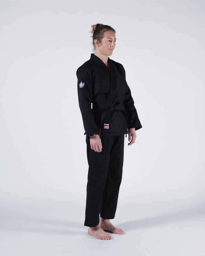 Kingz Empowered Women's Jiu Jitsu Gi - Black - Full Body Side View Female Athlete Black Gi Pink Crown Sleeve Patch KINGZ Logo Hem Durable Stitching Comfortable Fit BJJ Gi Training [color:Black]
