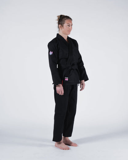 Kingz Empowered Women's Jiu Jitsu Gi - Black - Full Body Side View Female Athlete Black Gi Pink Crown Sleeve Patch KINGZ Logo Hem Durable Stitching Comfortable Fit BJJ Gi Training [color:Black]