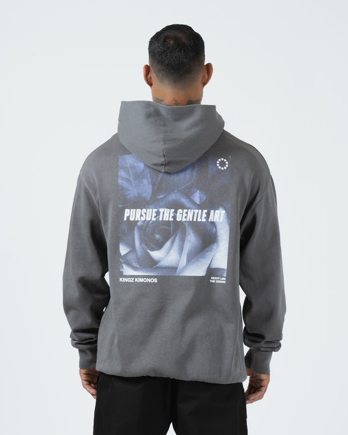 Grey BJJ hoodie back view on adult male model showing centered Pursue The Gentle Art rose photo graphic [color:Grey]