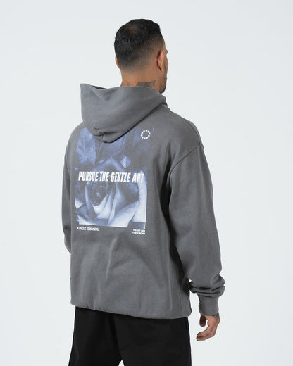 Grey BJJ hoodie rear side profile on adult male model showing angled Pursue The Gentle Art back print [color:Grey]