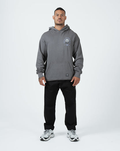 Grey BJJ hoodie full body lifestyle shot with adult male model in black joggers and grey sneakers [color:Grey]