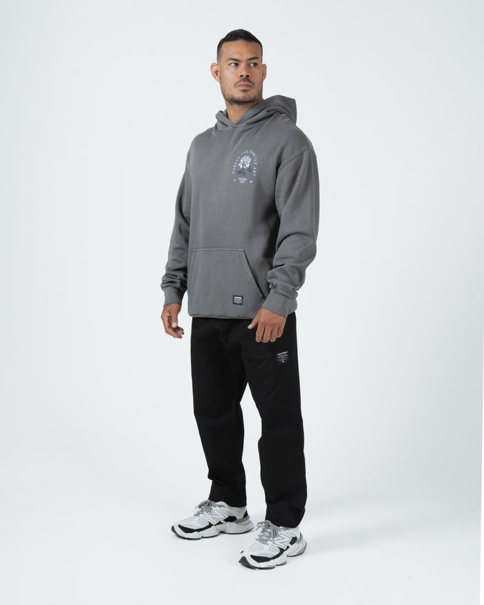 Grey BJJ hoodie full length angled front shot with adult male model in black joggers streetwear styling [color:Grey]