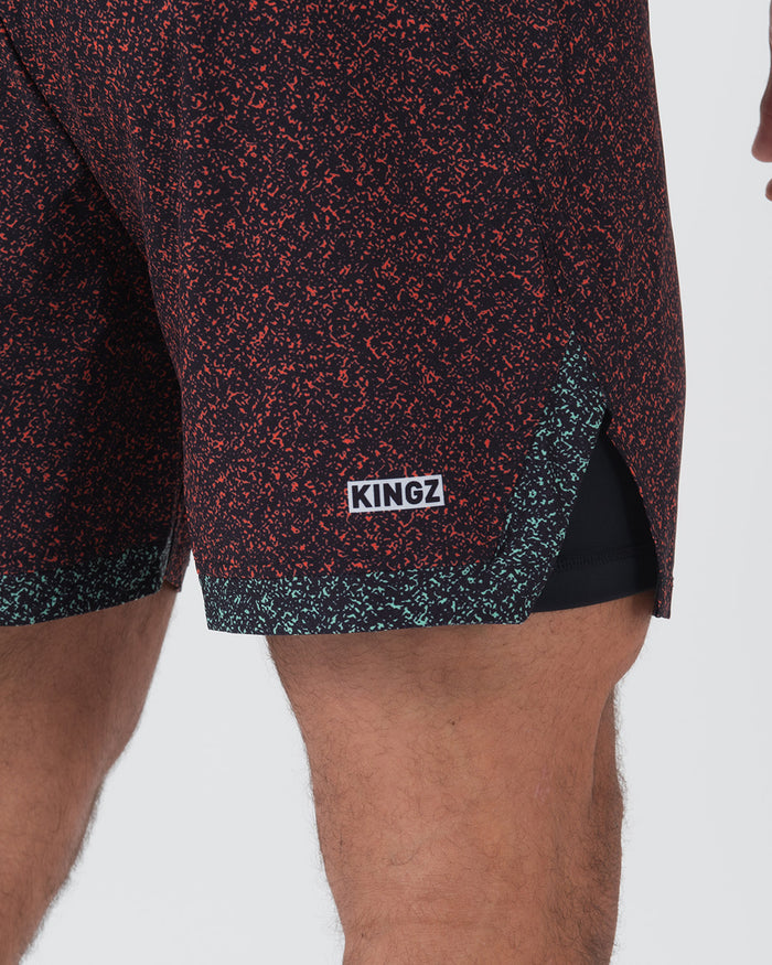 Kingz Hybrid Shorts Noise Red - Close Up Detail View Black Base Orange Coral Noise Speckle Pattern KINGZ White Text Box Badge Lower Right Teal Mint Inner Compression Shorts Hem Black Side Panel Sublimated Texture [color:Noise Red]