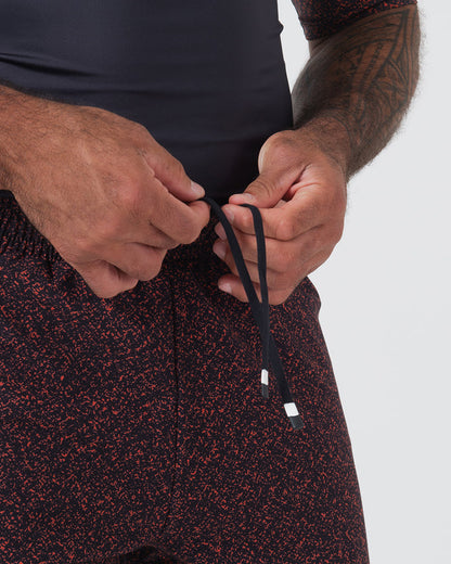 Kingz Hybrid Shorts Noise Red - Product Detail Close Up Black Base Orange Coral Noise Speckle Sublimated Pattern KINGZ Badge Teal Mint Inner Compression Shorts Men's Grappling Shorts No-Gi BJJ [color:Noise Red]