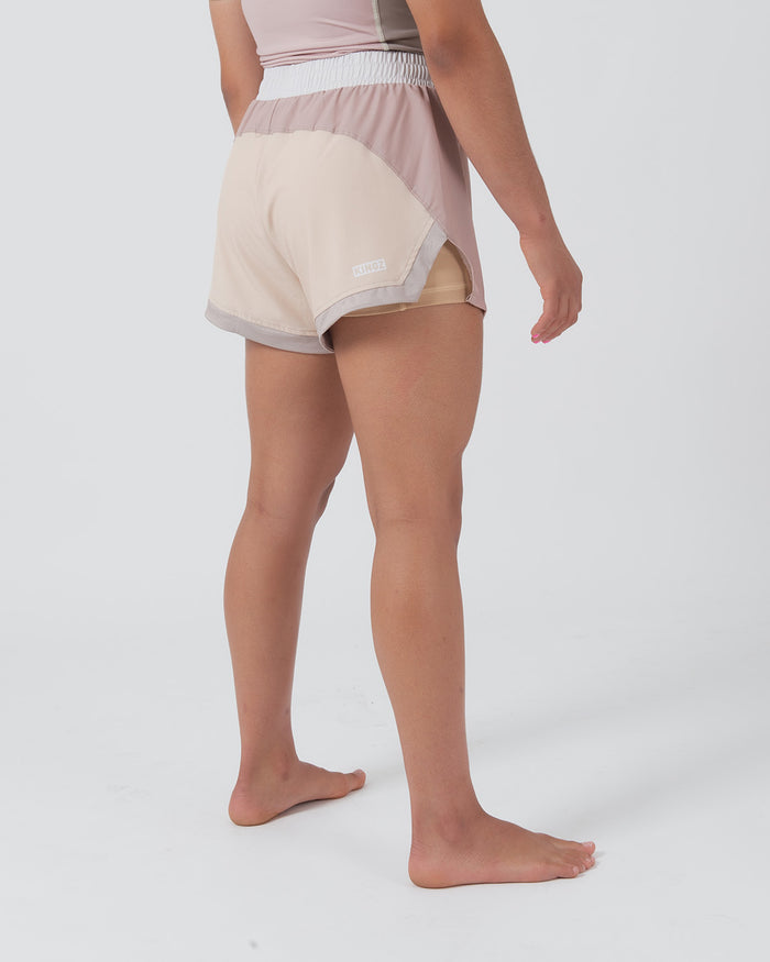 Kingz Hybrid Women's Shorts Terra Soil - Full Body Left Side Profile Female Athlete Two-Tone Cream Sand Back Dusty Rose Front Panel KINGZ Badge Right Side Gray Trim Inner Lining Visible Competition Cut Women's Grappling Shorts No-Gi BJJ [color:Baby Pink]