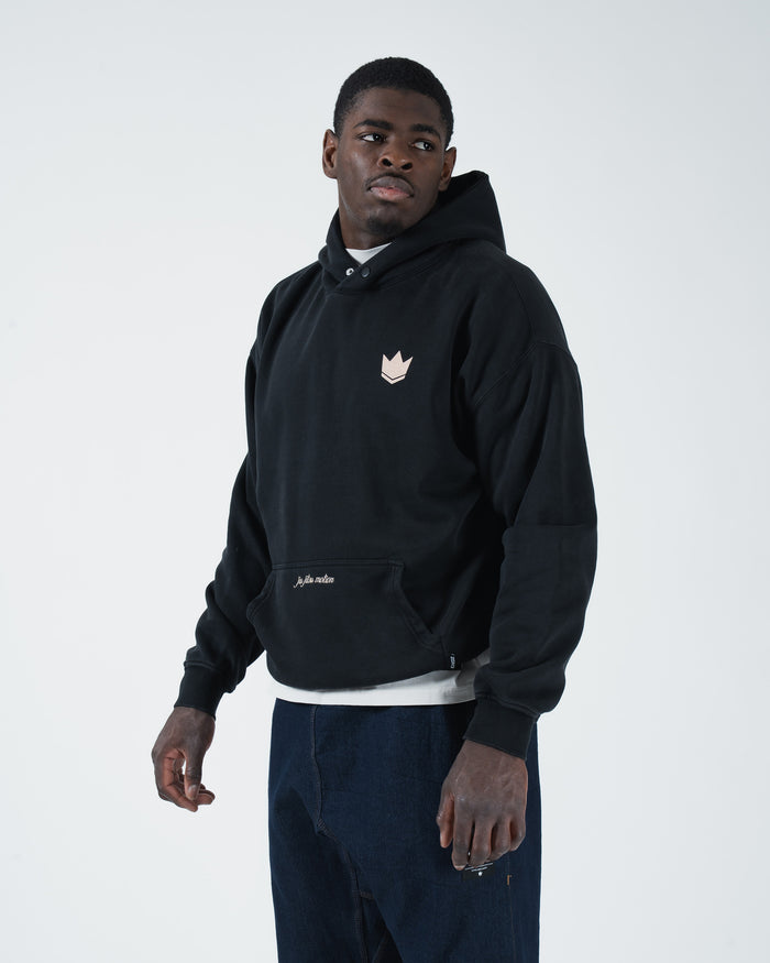Black BJJ hoodie front three-quarter view on adult male model showing crown chest logo and relaxed fit [color:Black]
