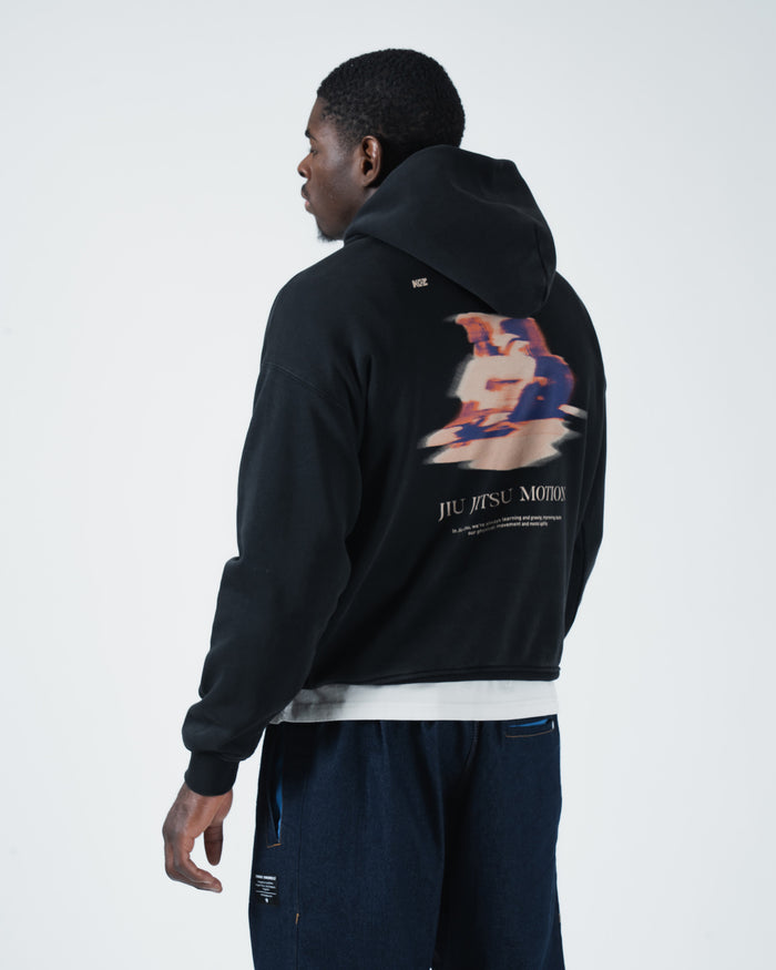 Black BJJ hoodie angled front pose on adult male model highlighting jiu jitsu motion pocket script detail [color:Black]