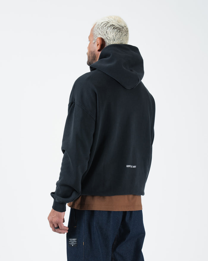 Black BJJ pullover hoodie back view on adult male model showing clean rear panel and drawstring hood [color:Black]