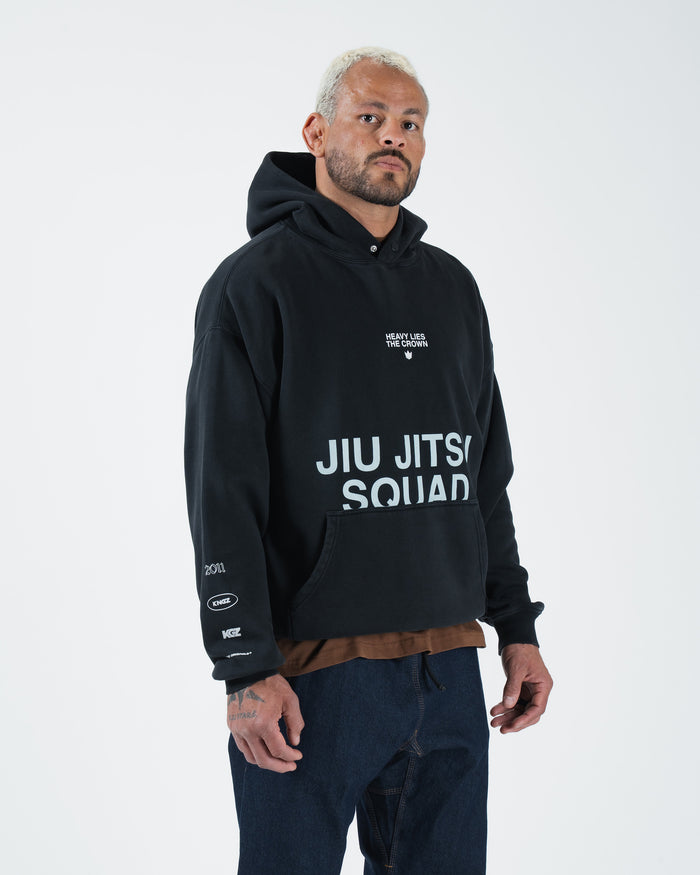 Black BJJ hoodie front three-quarter view on adult male model with Jiu Jitsu Squad print and sleeve logos [color:Black]