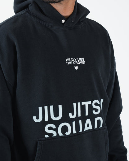 Black BJJ hoodie closeup detail of Heavy Lies The Crown crown logo and Jiu Jitsu Squad chest print [color:Black]