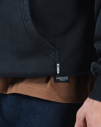 Black BJJ hoodie hem detail closeup showing woven Kingz brand label and ribbed bottom cuff stitching [color:Black]