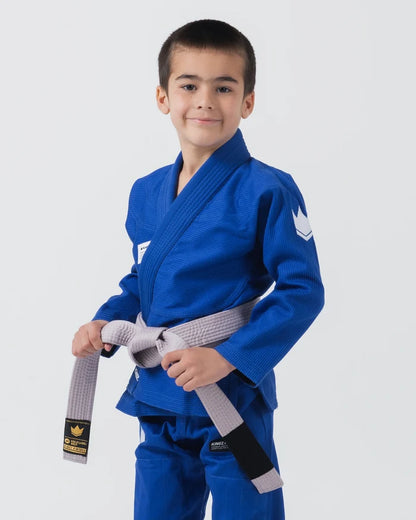 Kingz Kore V2 Youth BJJ Gi Blue - Upper Body 3/4 Angled Front View Young Athlete Gray Belt Crown Logo Sleeve Youth Kids