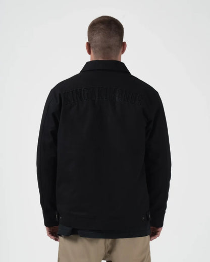 Kingz Mechanic Jacket Black - Back View Male Athlete Black KINGZ KIMONOS Text Across Shoulders Durable Outerwear Design Casual Fit BJJ Training Apparel [color:Black]