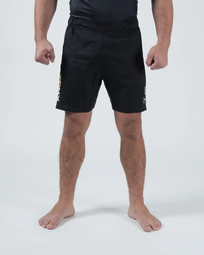 Kingz Player Special Limited Edition Shorts Black Gold - Full Body Front View Male Athlete All-Black KINGZ Gold Text Left Leg Gold Crown Badge Right Thigh Black Elastic Waistband Competition Cut Men's Grappling Shorts No-Gi BJJ Tainan Dalpra Signature Collection [color:Black]
