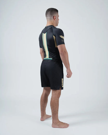 Kingz Player Special Limited Edition Rashguard Black Gold - Full Body 3/4 Back View Barefoot Male Athlete Short Sleeve Gold Vertical Stripe Back Panel Winged Crown Logo Motorsport [color:Black]