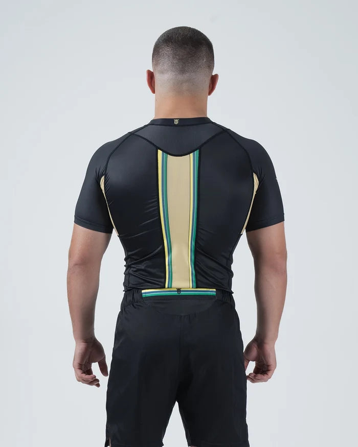 Kingz Player Special Limited Edition Rashguard Black Gold - Upper Body Back Detail View Male Athlete Short Sleeve Gold Champagne Center Stripe Teal Green Border Lotus JPS F1 Inspired [color:Black]