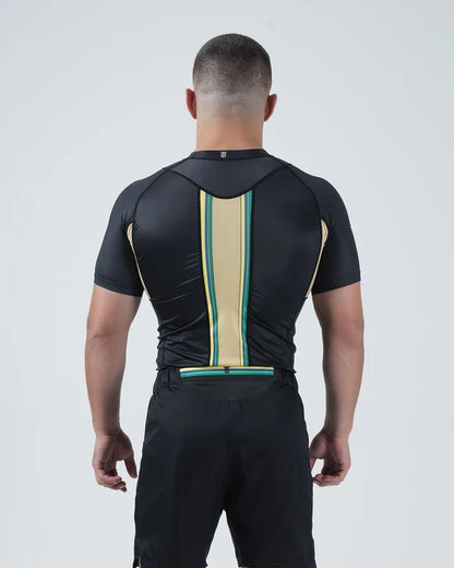 Kingz Player Special Limited Edition Rashguard Black Gold - Upper Body Back Detail View Male Athlete Short Sleeve Gold Champagne Center Stripe Teal Green Border Lotus JPS F1 Inspired [color:Black]