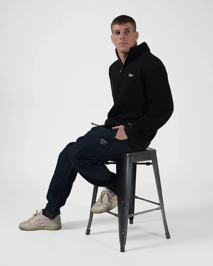 Kingz Script Quarter Zip Sweater Black - Seated Male Model Side View Black Sweater White Script Logo Chest Quarter Zip Casual Fit Hoodie BJJ Training Apparel [color:Black]