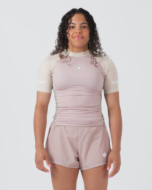 Kingz Terra Women's Rashguard Soil Edition - Full Body Front View Female Athlete Short Sleeve Dusty Rose Mauve Body Cream Beige Raglan Sleeves White Crown Logo Chest KINGZ White Text Sleeve Matching Dusty Rose Hybrid Shorts Women's BJJ No-Gi [color:Baby Pink]