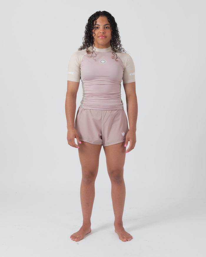 Kingz Terra Women's Rashguard Soil Edition - Full Body Front View Female Athlete Short Sleeve Dusty Rose Mauve Body Cream Beige Raglan Sleeves Crown Logo KINGZ Text Matching Mauve Hybrid Shorts Barefoot Stance Women's BJJ Terra Collection [color:Baby Pink]