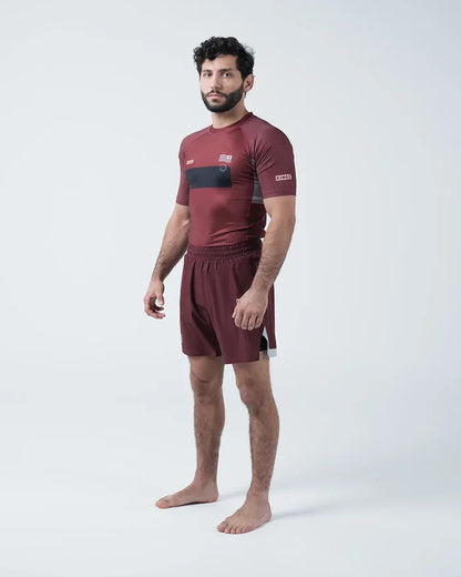 Kingz Trooper Rashguard Maroon - Full Body 3/4 Angled Front View Male Athlete Barefoot Short Sleeve KINGZ Logo Black Chest Band Flag Patches Maroon Shorts [color:Maroon]