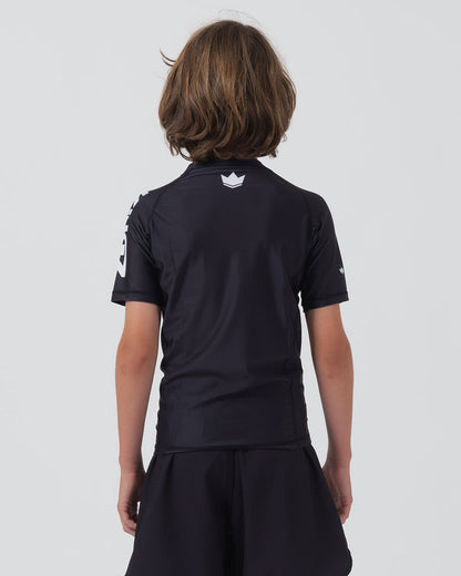Kingz Kore V2 Youth S/S Rashguard Navy Black - Full Body Back View Teen Boy Athlete Short Sleeve Navy Blue Minimal White Crown Logo Upper Back Center KINGZ White Sleeve Text Visible Matching Navy Shorts Kids BJJ Kore V2 [color:Black]